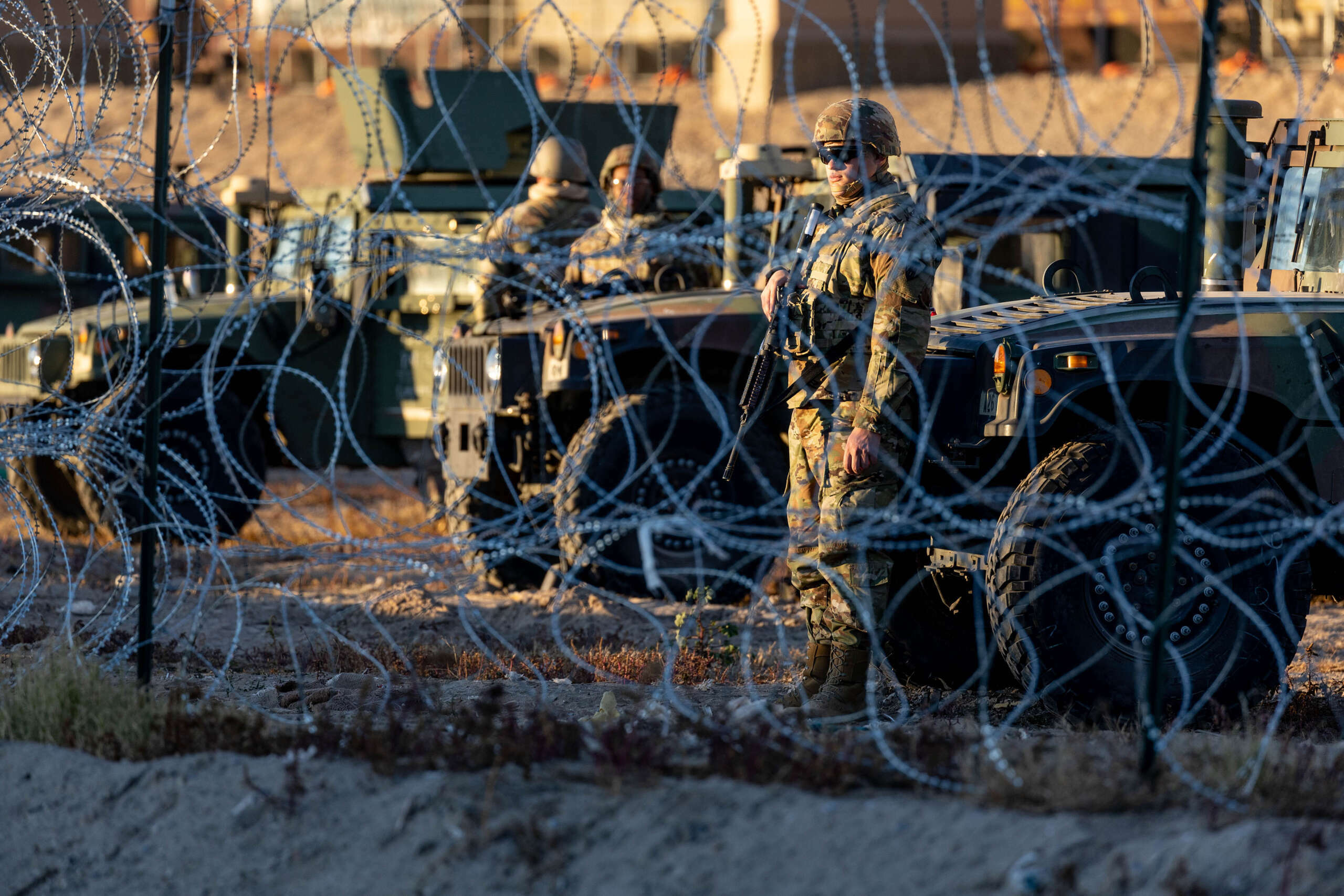 Texas National Guard soldiers stand guard behind concertina wire at the U.S.-Mexico border on December 21, 2022, as seen from Ciudad Juárez, Mexico.