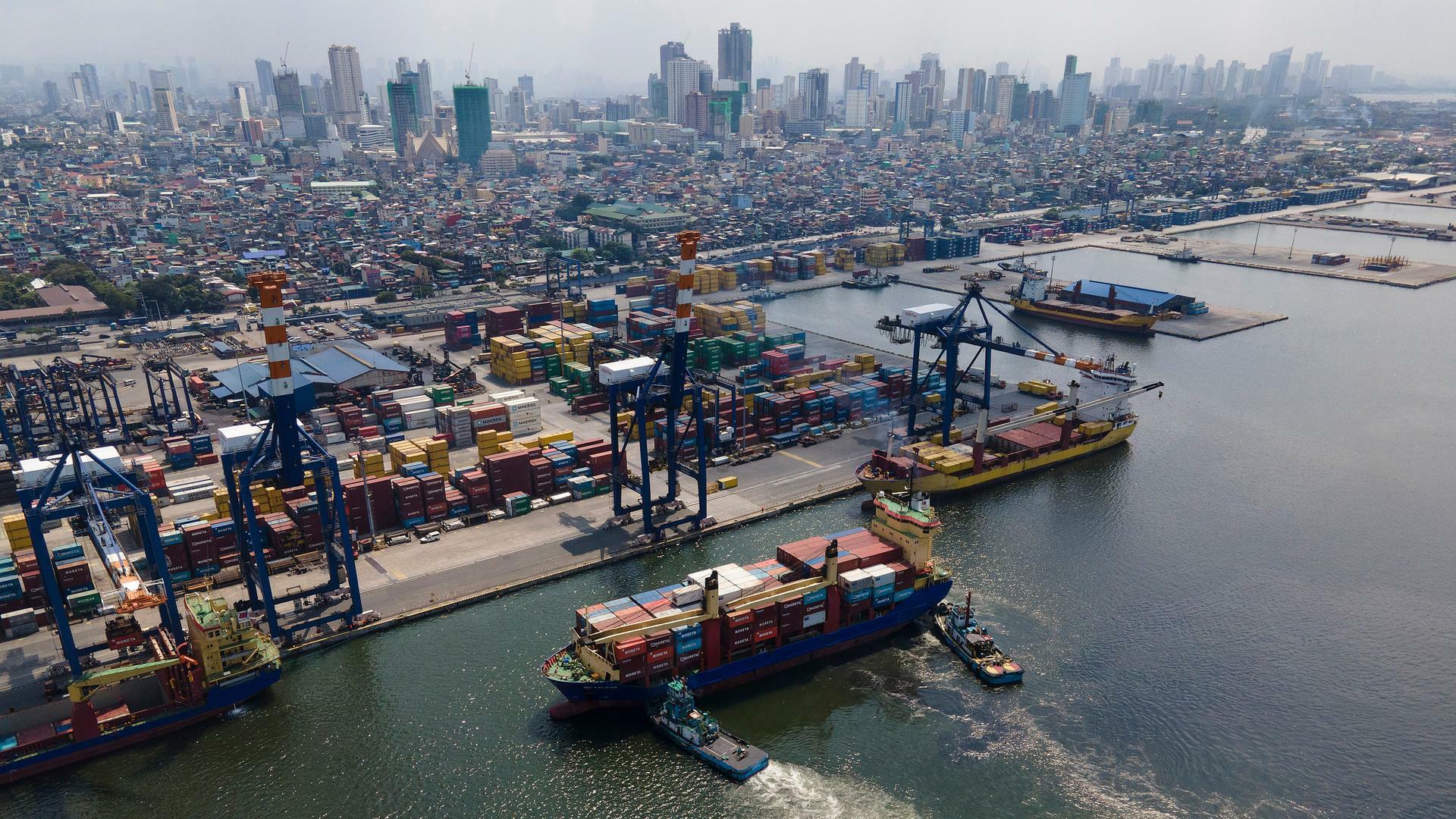 Ein voll beladenes Containerschiff wird in den Hafen von Manila gezogen.