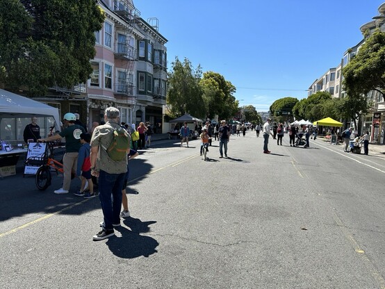 People walk and bike and stroll on a car-free street