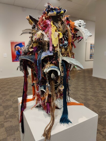 A cacophonous looking assemblage of colorful bits of fabric, strings, glasses, potshards and more.