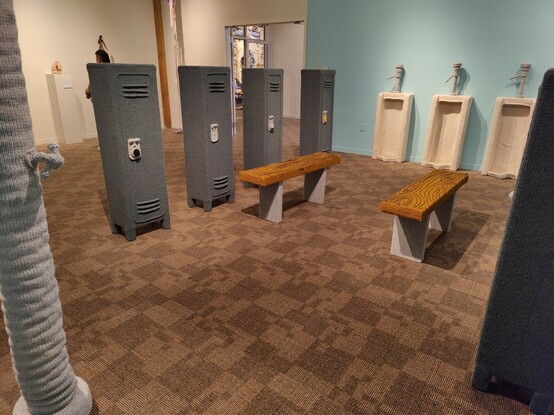 A woven fabric version of a men's locker room, complete with woven lockers, benches, showers and urinals.