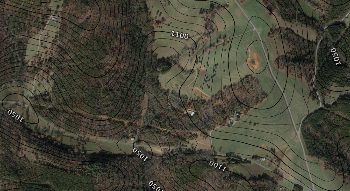 Satellite photo of a part cleared / part forested landscape overlaid with contour lines. Snip from a larger map.