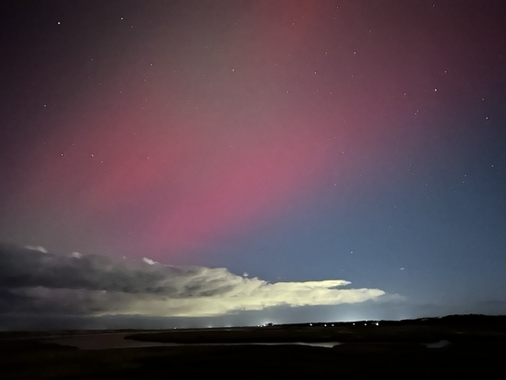 Pink northern lights over the cape cod bay