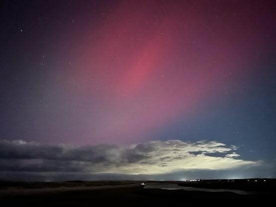 Deep pink northern lights over cape cod bay