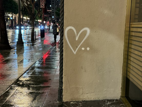 A photograph of a white graffiti heart on the side of a building in downtown Los Angeles. 