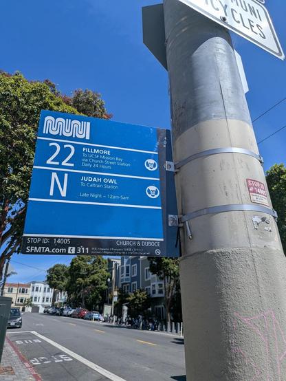 Official SFMTA bus stop sign with Muni logo and details on the 22 Fillmore to UCSF Mission Bay via Church Street Station, and N Judah Owl to Caltrain station. Stop ID: 14005, Church & Duboce.