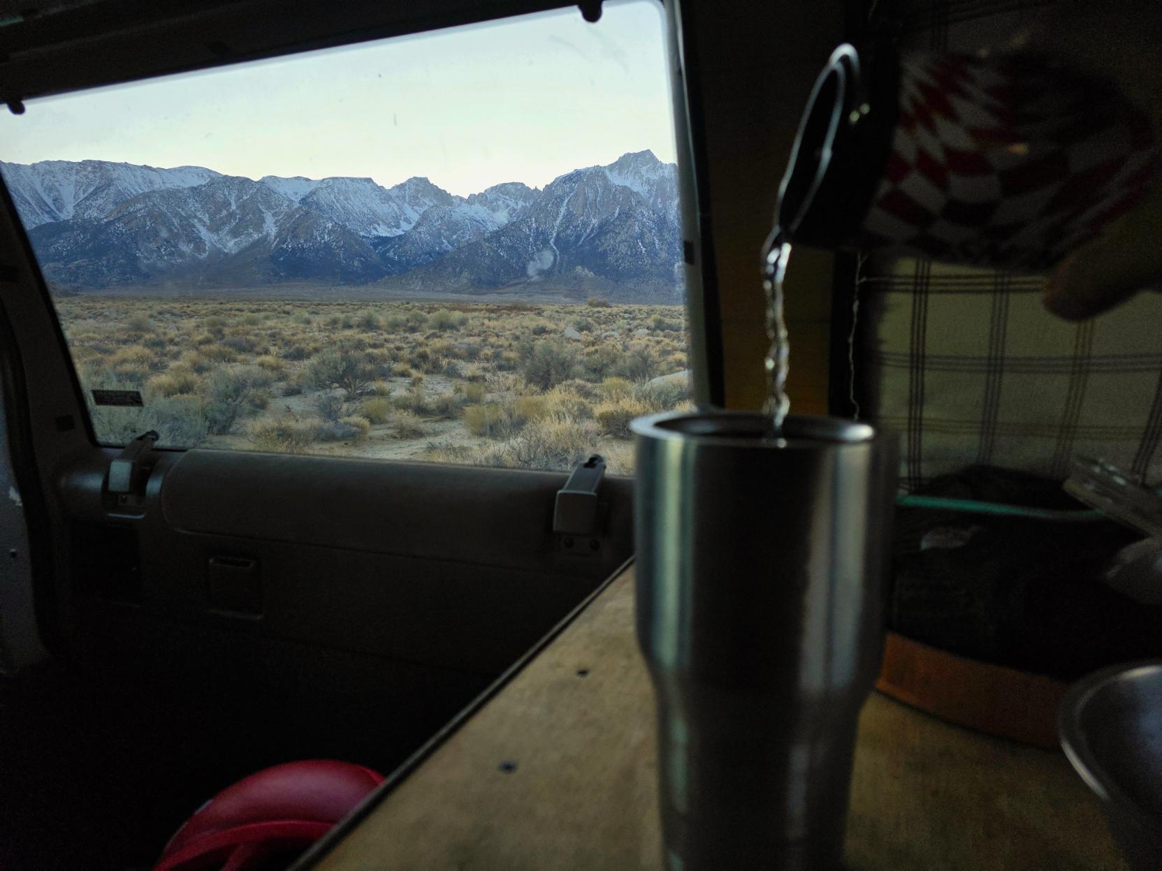 Pouring hot water into a cup with alpine views out the window