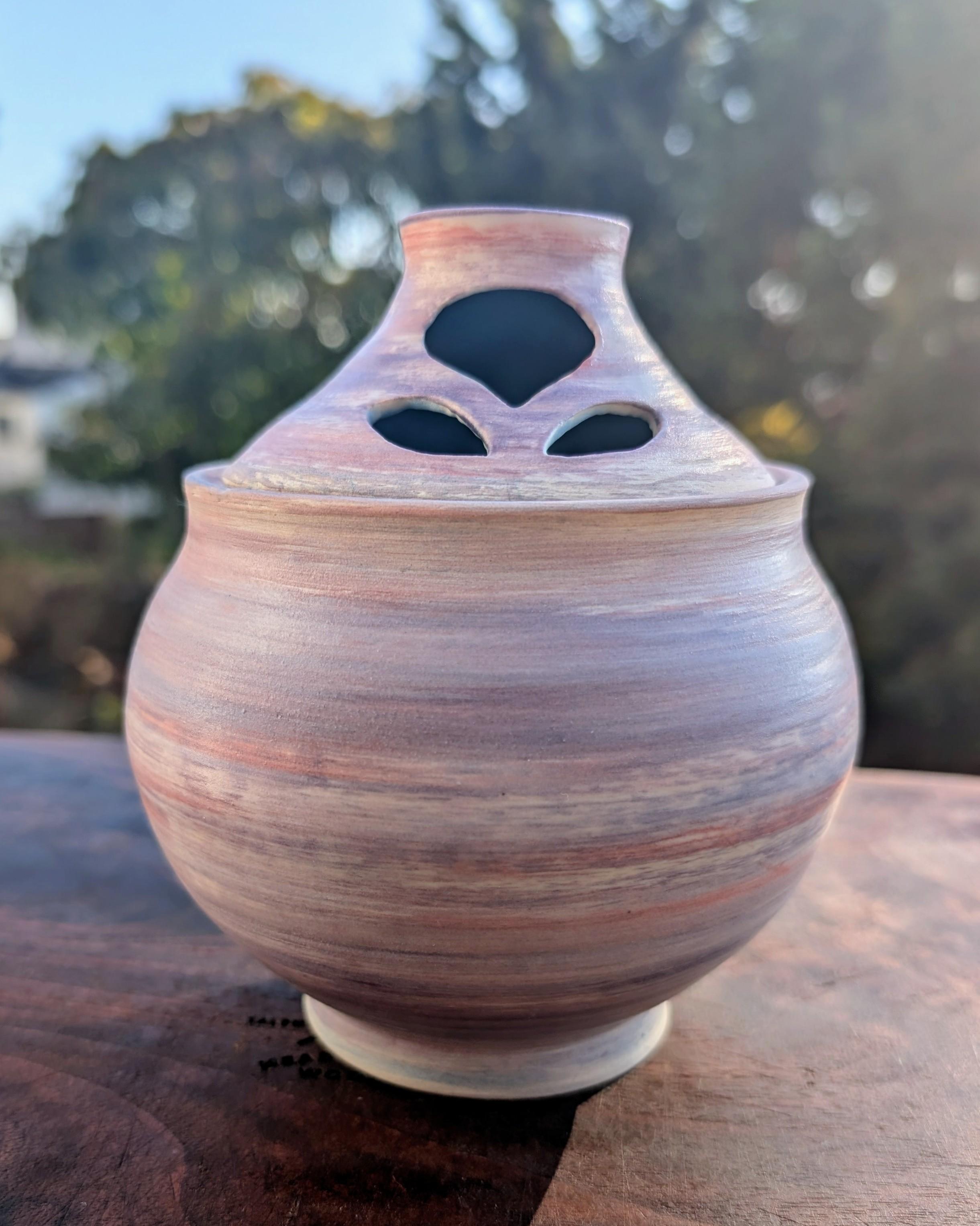 A wheel-thrown bulb-shaped covered pot. The lid has holes in it to let the garlic breathe. The pot is underglazed in streaks of white, purple, and pink, reminiscent of purple garlic. CC BY-SA 4.0 Kate Zimmerman.